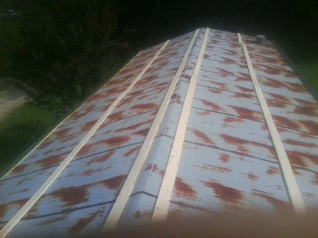 Rusted metal roof panels with new wood purlins before replacement — Storm Damage Roof Repair in Mc Louth by Roofing Brothers