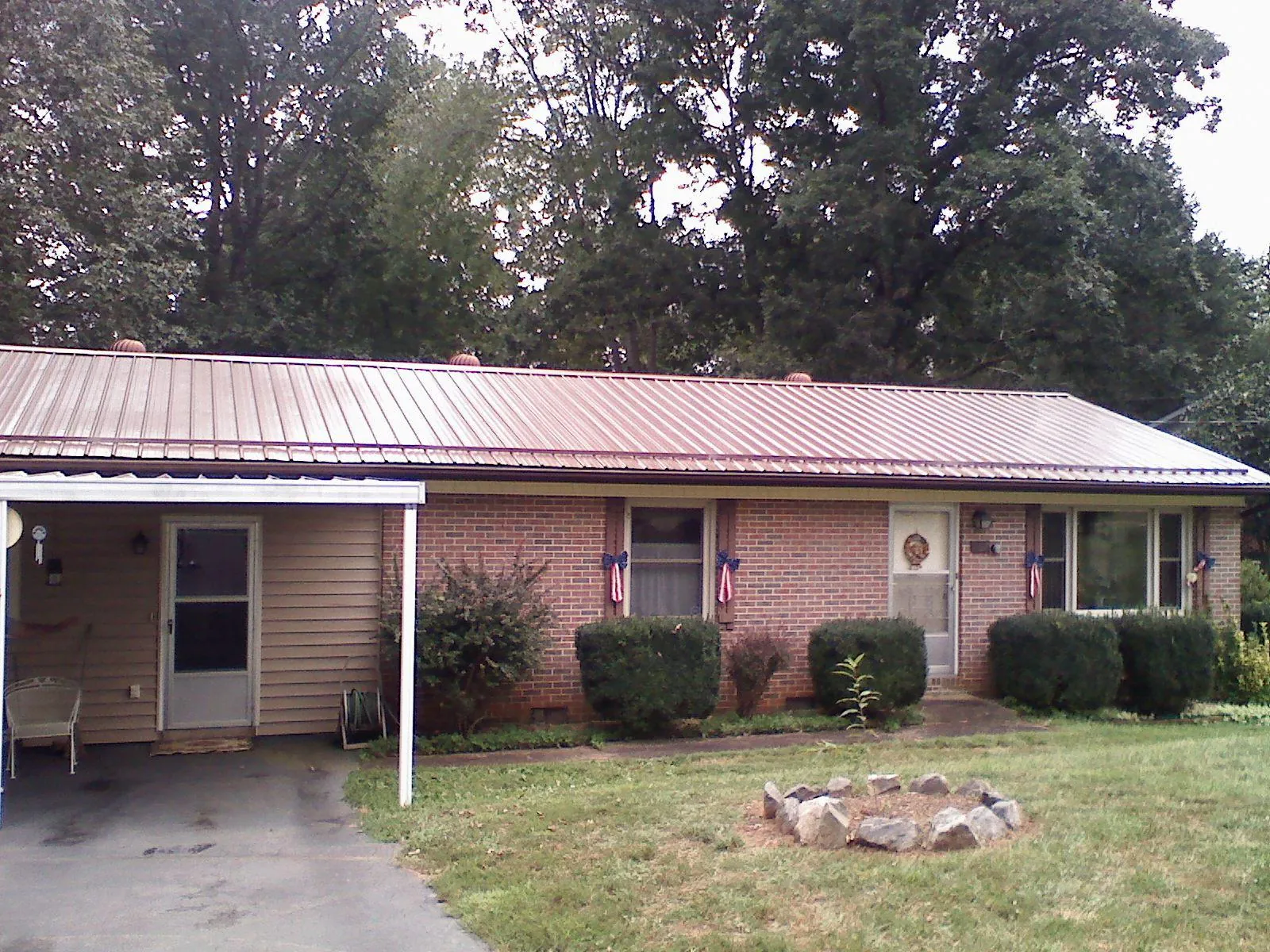Bronze metal roof and carport on a brick ranch home — Roof Repair work by our crew in Mc Louth